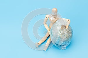 .World Environment Day concept. Symbol wooden man and planet earth globe. The consequence of environmental pollution will be the