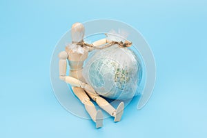 .World Environment Day concept. Symbol wooden man and planet earth globe. The consequence of environmental pollution will be the