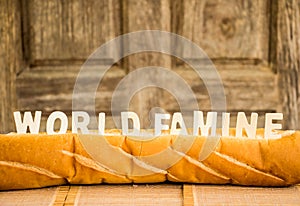 World famine word on baguette with wood background