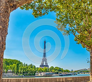 World famous Eiffel tower by Seine river under a blue sky