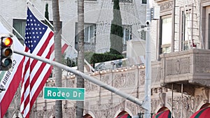 World famous Rodeo Drive Street Road Sign in Beverly Hills against American Unated States flag. Los Angeles, California