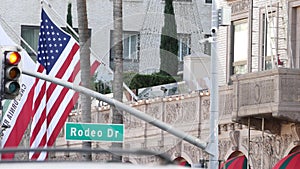 World famous Rodeo Drive Street Road Sign in Beverly Hills against American Unated States flag. Los Angeles, California, USA. Rich