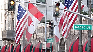 World famous Rodeo Drive Street Road Sign in Beverly Hills against American Unated States flag. Los Angeles, California, USA. Rich