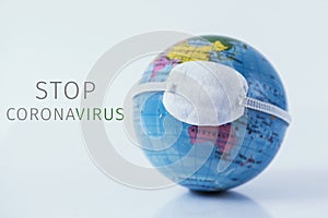 World globe with a mask and text stop coronavirus