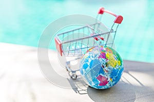 World hand stress releif massage ball with empty shopping cart on swimming pool edge