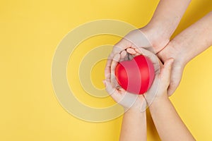 World health day, adult and child hands holding red heart, healthcare, love and family insurance concept