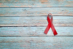 World health day, healthcare and medical concept, red ribbon on the blue wooden background