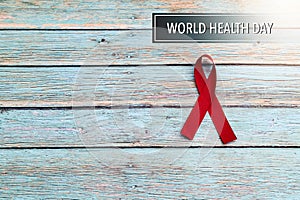 World health day, healthcare and medical concept, red ribbon on the blue wooden background