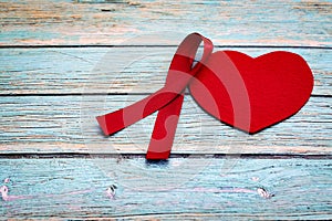 World health day, healthcare and medical concept, red ribbon and red heart on the blue wooden background