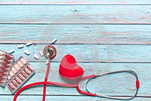 World health day healthcare and medical concept red stethoscope and medicine on the blue wooden background