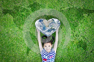 World heart day concept and well being health care campaign with smiling happy kid on eco friendly green lawn. photo