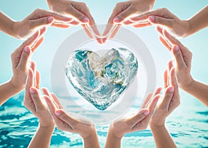 World heart day and environmental protection concept with love earth in community volunteer`s hands.