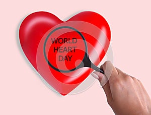 World Heart Day. Red heart in magnifier. close up.