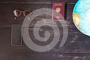 World map and items on wooden background, flat lay. summer travel wanderlust concept, space for text. map camera sunglasses