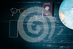 World map and items on wooden background, flat lay. summer travel wanderlust concept, space for text. map camera sunglasses