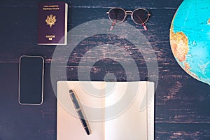 World map and items on wooden background, flat lay. summer travel wanderlust concept, space for text. map camera sunglasses