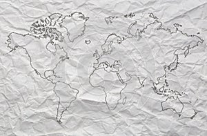 World map outline on white crumpled paper