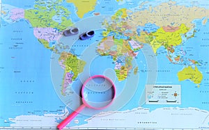 World map and magnifying glass photo