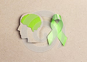 World mental health day concept. Green awareness ribbon and brain symbol