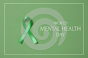 World Mental Health Day. Green ribbon on color background, top view