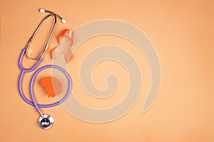 World Multiple Sclerosis Day.Orange awareness ribbon, brain symbol and stethoscope  on a orange background