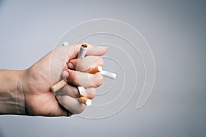 World No Tobacco Day, May 31. STOP Smoking. Close up Man hand crushing and destroying cigarettes on gray background