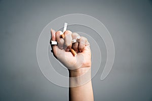 World No Tobacco Day, May 31. STOP Smoking. Close up Man hand crushing and destroying cigarettes on gray background