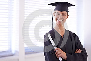 The world is now her oyster. Portrait of a young woman in a graduation gown holding a diploma.