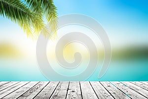 World Oceans Day concept: Empty wooden board on Palm leaves and Abstract blurred beach with sunset sky background