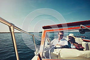 The world is our oyster. an affectionate young couple sailing on the open seas in their yacht.