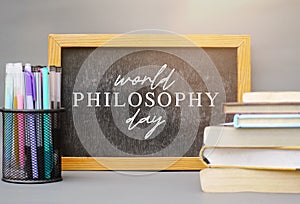 World Philosophy Day. Stack of books with pens and lettering on white background.