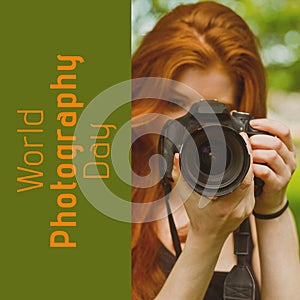 World photography day text in orange on green over red haired caucasian woman using camera outdoors