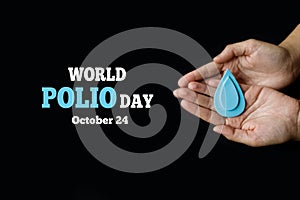 World Polio day. October 24. Adult hands holding Blue drop is symbol of polio vaccine. Poliomyelitis is disabling and