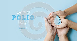 World Polio day. October 24. Blue drop in hands of an adult and child is symbol of polio vaccine. Poliomyelitis is