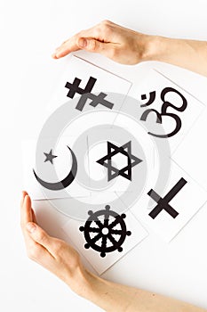 World religions concept. Hands hugs Christianity, Catholicism, Buddhism, Judaism, Islam symbols on white background top photo