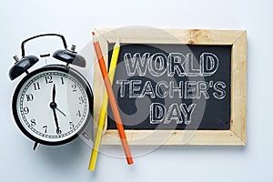 World Teacher`s Day Text. Alarm Clock, Color Pencil and Blackboa