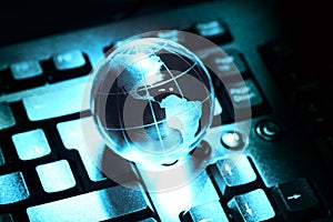 World transparent globe earth on computer keyboard. Global communications business concept. Blue toned