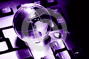 World transparent globe earth on computer keyboard. Global communications business concept. Ultraviolet colored Image. Color of th