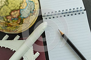 World travel concept with toy airplane, pencil , passport, note