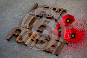 World War remembrance day. Red poppies on dark stone background. Lest we forget