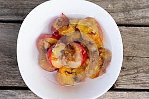 Wormy apricots on plates. Rotten apricots