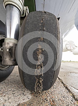 Worn aircraft chassis. Old tire in disrepair