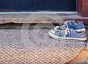 Worn Blue Shoes on doormat photo