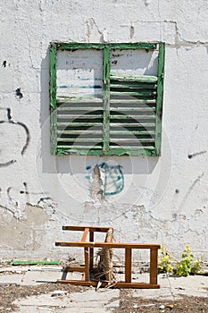 Worn building facade with green shutters