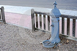 Worn classic fountain for children to drink and cool off in a children`s playground in the autumn season by means of their