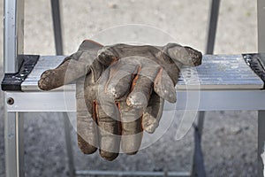 Worn and dirty worker gloves on ladders in Finland.