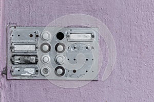 Worn doorbell with intercom on a house wall