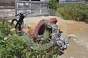 Worn-out scooter or go-cart is left in a deserted driveway