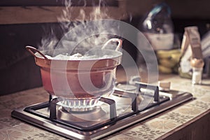 Worn out stove pot or cooking pan on a burning gas hob