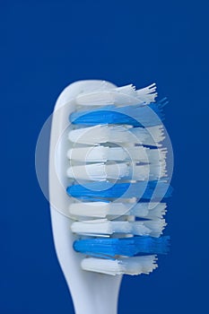 Worn out toothbrush against blue background